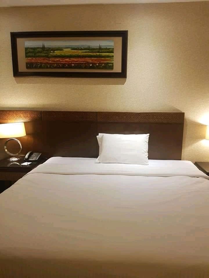 Classic hotel bedroom with framed landscape art